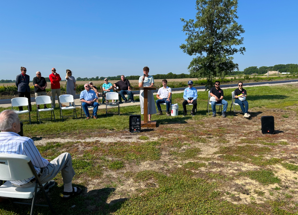 Tami Koenigs, Sustainability Manager at Goodwill of the Great Plains, speaks to an assembled crowd during a ceremony to commemorate the new plastic-bag asphalt road being poured on Foundry Rd. in South Sioux City, Nebraska on June 11th, 2025.